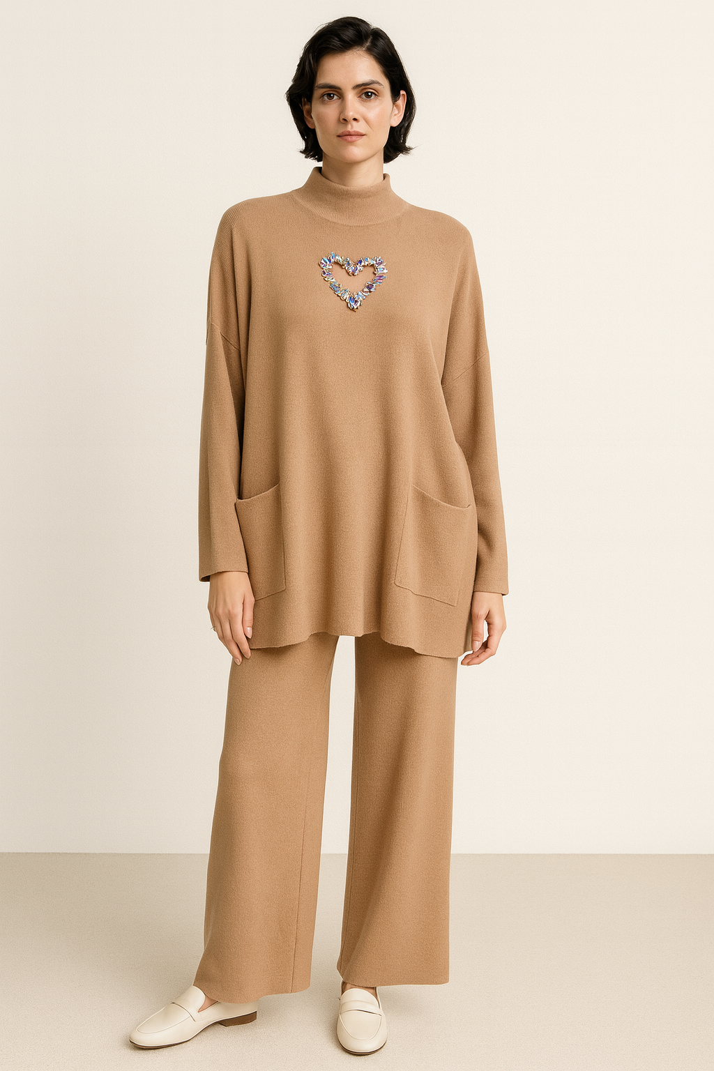 Kostum bezhë trikote me bluzë të gjerë dhe detaj zemre